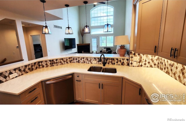 451 Clubhouse Ct, Loveland, CO 80537 - kitchen featuring stainless steel dishwasher, a sink, light countertops, backsplash, and decorative light fixtures
