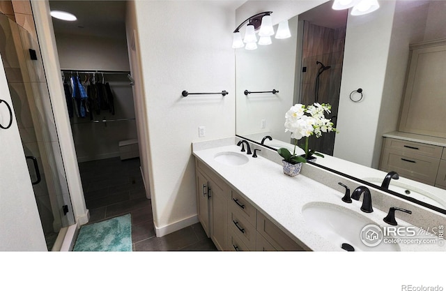 451 Clubhouse Ct, Loveland, CO 80537 - full bathroom featuring tile patterned floors, a shower stall, double vanity, a walk in closet, and baseboards