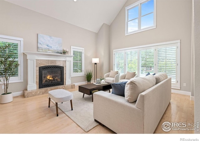 1509 Poplar Ave, Boulder, CO 80304 - living area featuring high vaulted ceiling, wood finished floors, a tile fireplace, and healthy amount of natural light