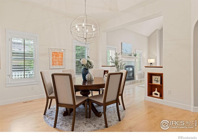 1509 Poplar Ave, Boulder, CO 80304 - dining area featuring a chandelier, light wood-style flooring, lofted ceiling, and a tiled fireplace