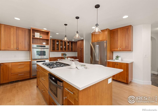 1509 Poplar Ave, Boulder, CO 80304 - kitchen with appliances with stainless steel finishes, recessed lighting, brown cabinetry, light wood finished floors, and tasteful backsplash
