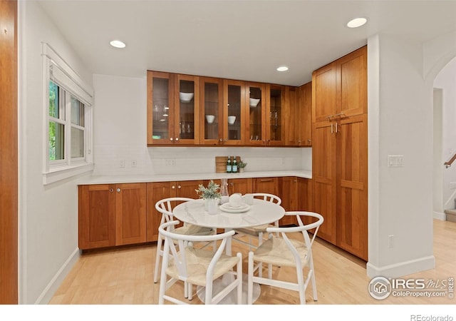 1509 Poplar Ave, Boulder, CO 80304 - kitchen with arched walkways, brown cabinets, glass insert cabinets, light wood finished floors, and recessed lighting