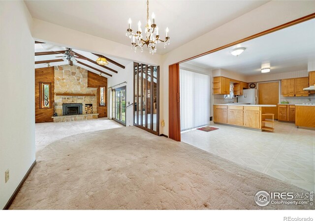 912 Diana St, Fort Morgan, CO 80701 - unfurnished living room featuring a chandelier, a ceiling fan, a fireplace, a sink, and light carpet