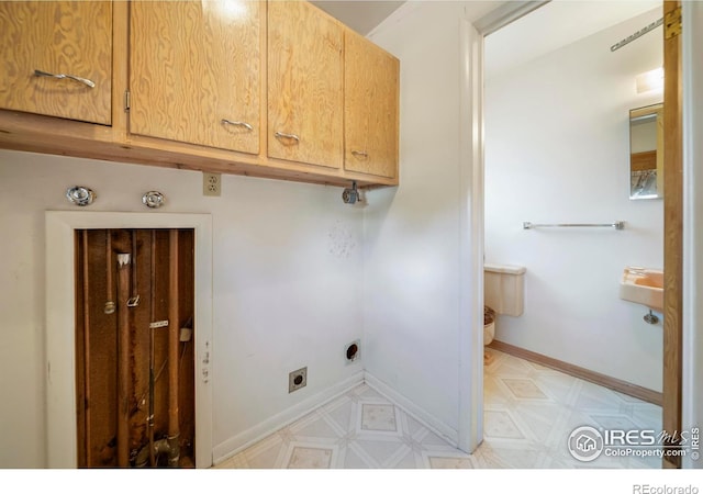912 Diana St, Fort Morgan, CO 80701 - laundry area featuring cabinet space, hookup for an electric dryer, light floors, and baseboards