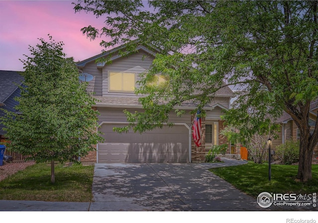 379 E 41st Ct, Loveland, CO 80538 - obstructed view of property with concrete driveway, an attached garage, brick siding, and a front lawn