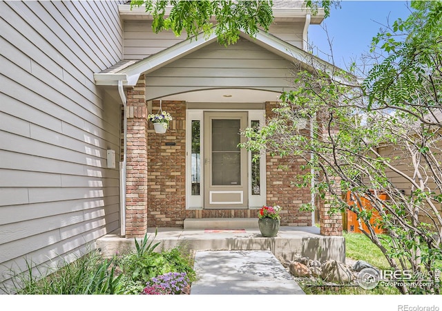 379 E 41st Ct, Loveland, CO 80538 - view of exterior entry with brick siding and a porch
