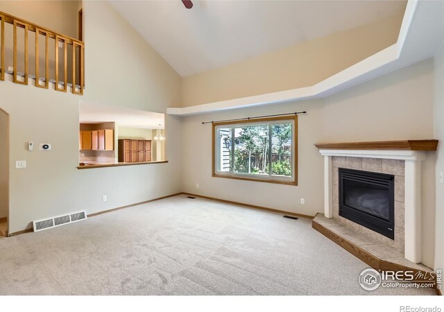 379 E 41st Ct, Loveland, CO 80538 - unfurnished living room with carpet floors, a fireplace, high vaulted ceiling, and baseboards