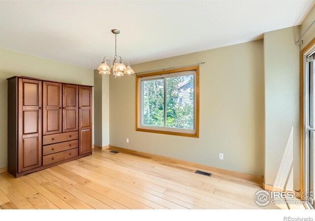 379 E 41st Ct, Loveland, CO 80538 - empty room with light wood-style floors, a chandelier, and baseboards