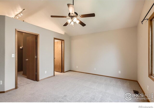379 E 41st Ct, Loveland, CO 80538 - unfurnished bedroom with light colored carpet, vaulted ceiling, baseboards, and ceiling fan