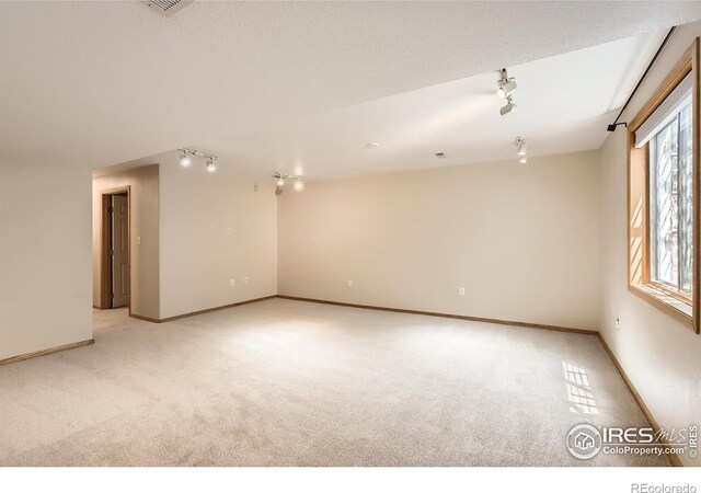 379 E 41st Ct, Loveland, CO 80538 - unfurnished room with rail lighting, light carpet, and baseboards
