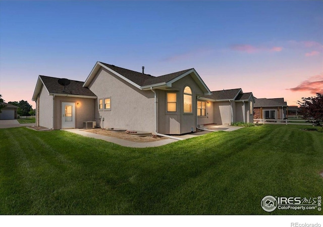 1365 Settlers Dr, Eaton, CO 80615 - back of house at dusk featuring a lawn and stucco siding