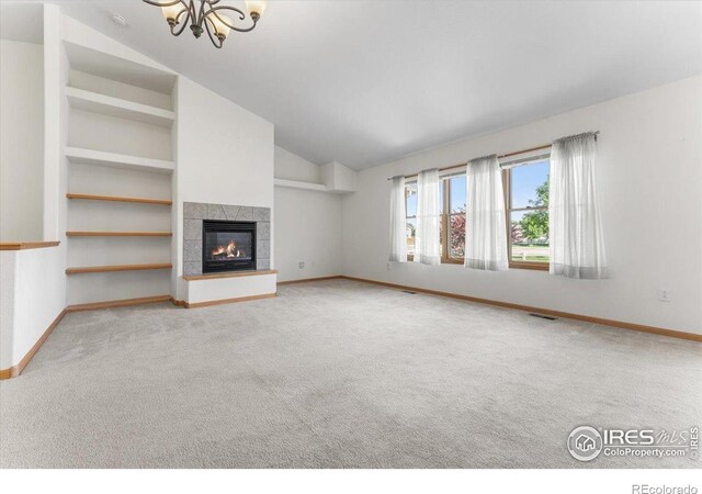 1365 Settlers Dr, Eaton, CO 80615 - unfurnished living room with carpet, vaulted ceiling, a chandelier, a tiled fireplace, and built in features