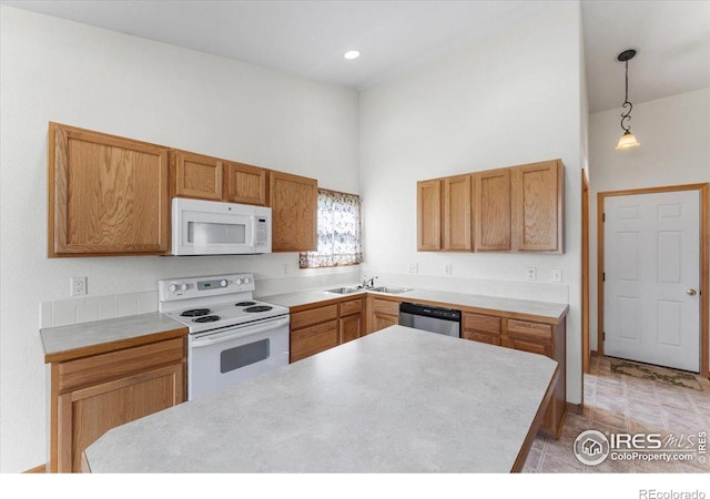 1365 Settlers Dr, Eaton, CO 80615 - kitchen featuring white appliances, a towering ceiling, light countertops, pendant lighting, and brown cabinetry