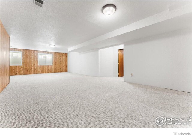 1365 Settlers Dr, Eaton, CO 80615 - carpeted empty room featuring wooden walls and a textured ceiling
