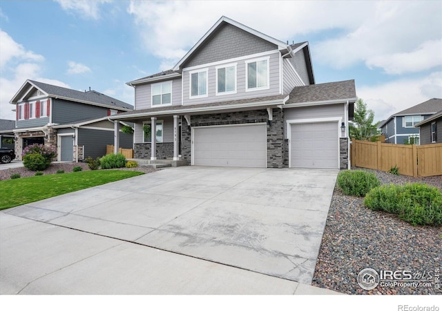 6793 Hayfield St, Wellington, CO 80549 - craftsman-style home with concrete driveway, stone siding, covered porch, and an attached garage