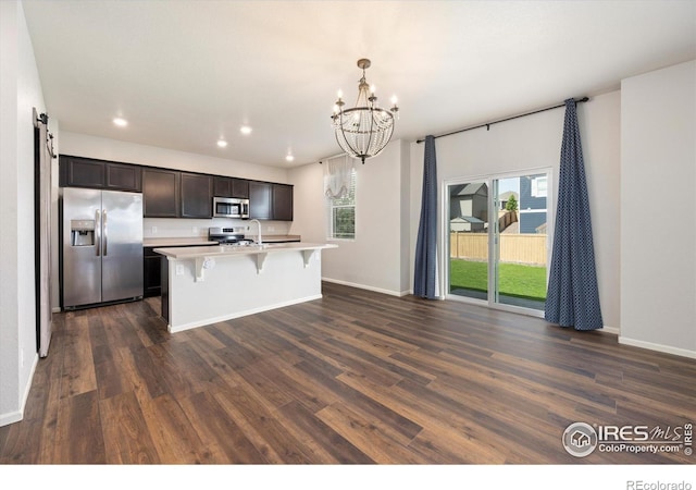 6793 Hayfield St, Wellington, CO 80549 - kitchen featuring appliances with stainless steel finishes, healthy amount of natural light, a chandelier, dark wood finished floors, and recessed lighting