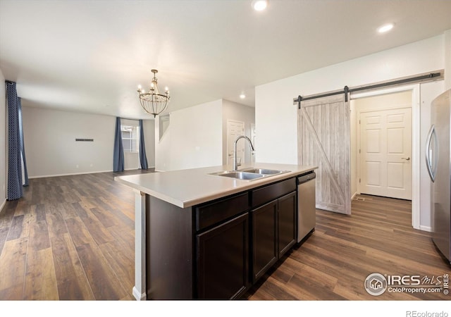 6793 Hayfield St, Wellington, CO 80549 - kitchen featuring a sink, appliances with stainless steel finishes, dark wood-style floors, a barn door, and recessed lighting