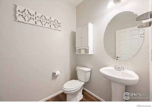6793 Hayfield St, Wellington, CO 80549 - bathroom featuring wood finished floors, toilet, and baseboards