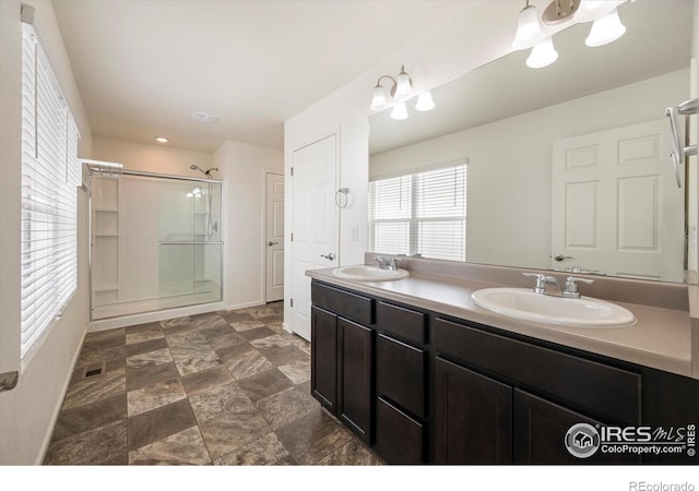 6793 Hayfield St, Wellington, CO 80549 - bathroom with an enclosed shower, double vanity, and baseboards