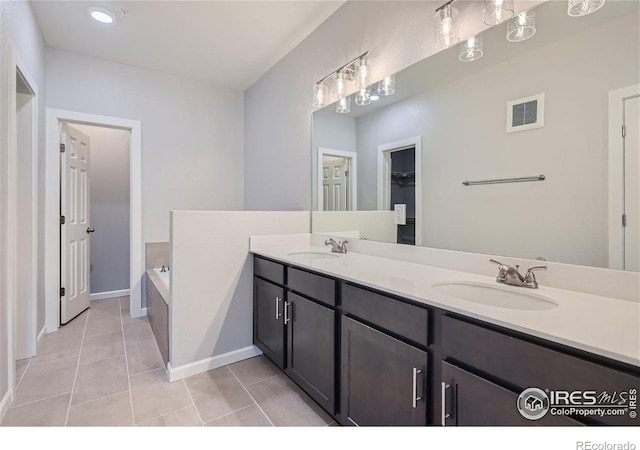 2435 Calais Dr Unit G, Longmont, CO 80504 - full bathroom featuring a garden tub, double vanity, tile patterned floors, baseboards, and a spacious closet