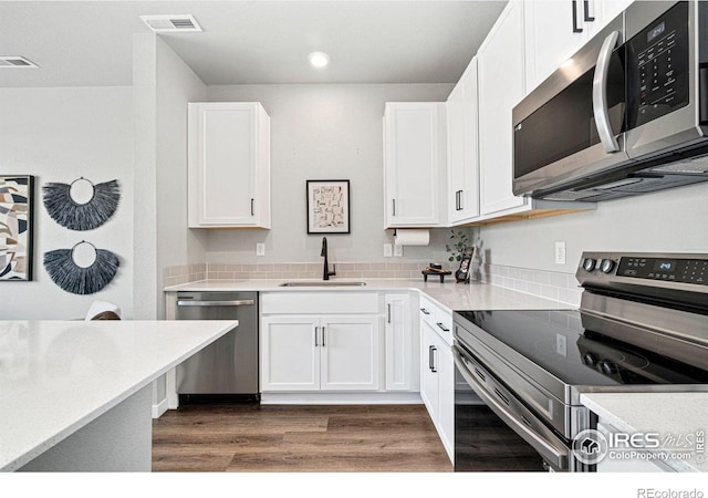 259 Molinar St, Johnstown, CO 80534 - kitchen featuring appliances with stainless steel finishes, a sink, dark wood-style floors, white cabinets, and recessed lighting