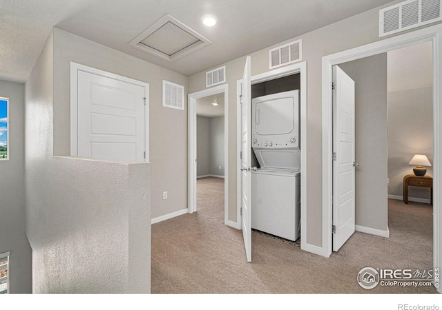 259 Molinar St, Johnstown, CO 80534 - laundry area featuring stacked washer / dryer, light colored carpet, and baseboards