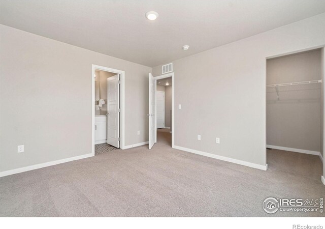 259 Molinar St, Johnstown, CO 80534 - unfurnished bedroom featuring carpet floors, baseboards, a walk in closet, connected bathroom, and recessed lighting