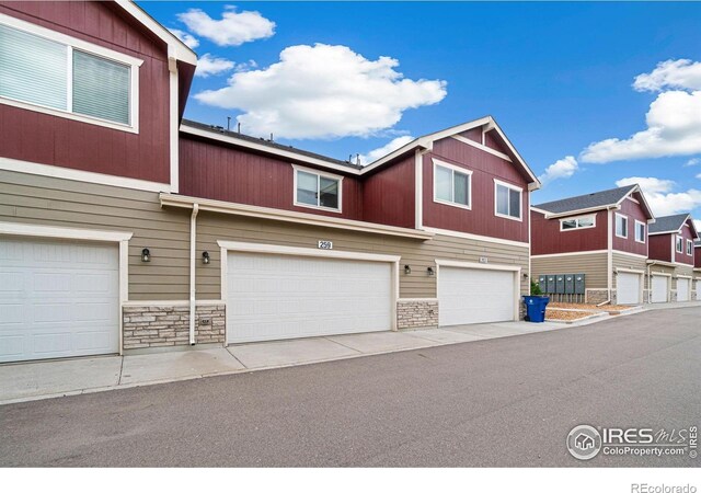 259 Molinar St, Johnstown, CO 80534 - townhome / multi-family property with stone siding and an attached garage