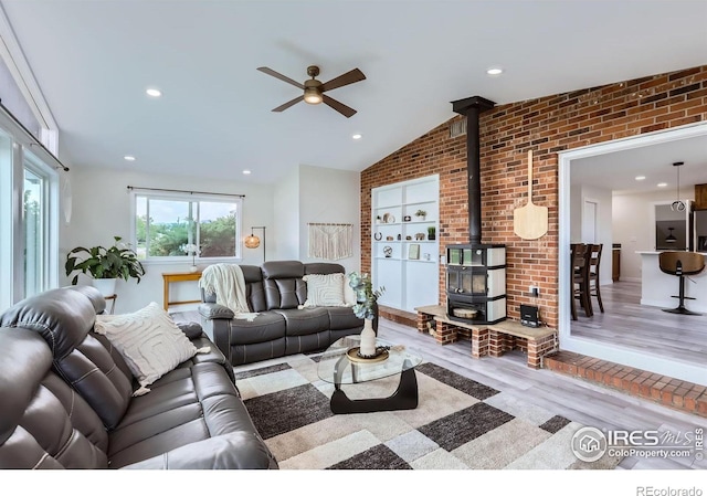 128 Carpenter Rd, Fort Collins, CO 80525 - living area with a wood stove, ceiling fan, wood finished floors, lofted ceiling, and brick wall