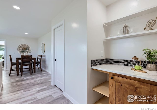 128 Carpenter Rd, Fort Collins, CO 80525 - kitchen featuring open shelves, brown cabinetry, light wood-style floors, recessed lighting, and light stone countertops
