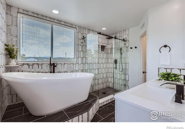 128 Carpenter Rd, Fort Collins, CO 80525 - full bath featuring marble tiled floors, a soaking tub, a shower stall, recessed lighting, and double vanity