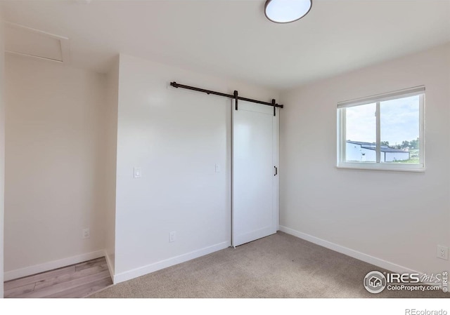 128 Carpenter Rd, Fort Collins, CO 80525 - unfurnished bedroom featuring baseboards and a barn door