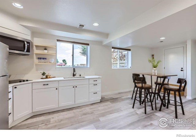 128 Carpenter Rd, Fort Collins, CO 80525 - kitchen featuring a sink, stainless steel microwave, recessed lighting, light countertops, and white cabinets
