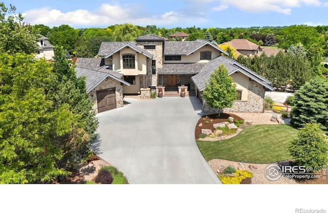 5709 Old Legacy Dr, Fort Collins, CO 80528 - view of front of house featuring stone siding, stucco siding, driveway, an attached garage, and a front yard