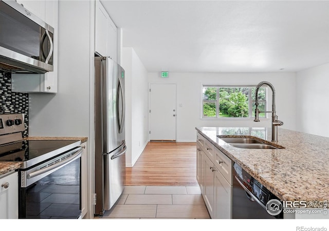 4462 Hamilton Ct, Boulder, CO 80305 - kitchen with appliances with stainless steel finishes, a sink, white cabinetry, light stone countertops, and light tile patterned floors