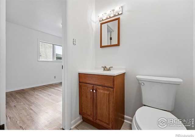 4462 Hamilton Ct, Boulder, CO 80305 - half bathroom featuring toilet, vanity, wood finished floors, and baseboards