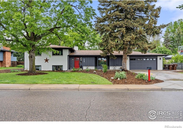 365 Mohawk Dr, Boulder, CO 80303 - tri-level home featuring concrete driveway, a garage, and a front lawn