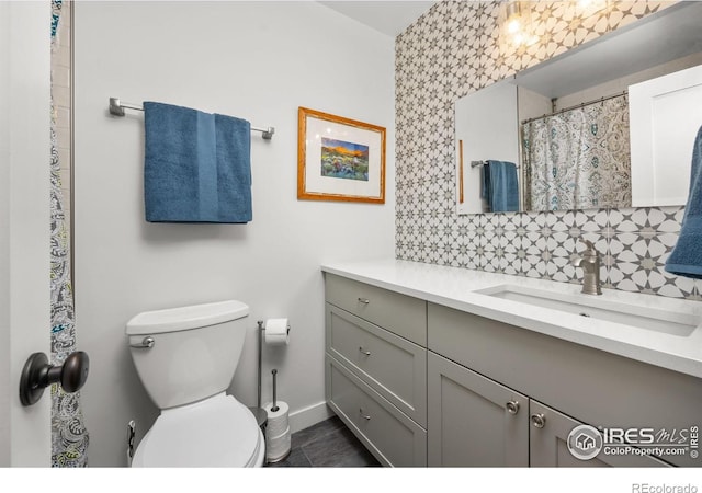 365 Mohawk Dr, Boulder, CO 80303 - bathroom with vanity, decorative backsplash, toilet, and baseboards