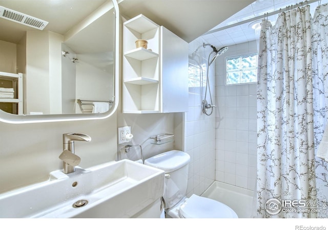 1233 Carolina Ave, Longmont, CO 80501 - bathroom featuring a sink, tiled shower, and toilet