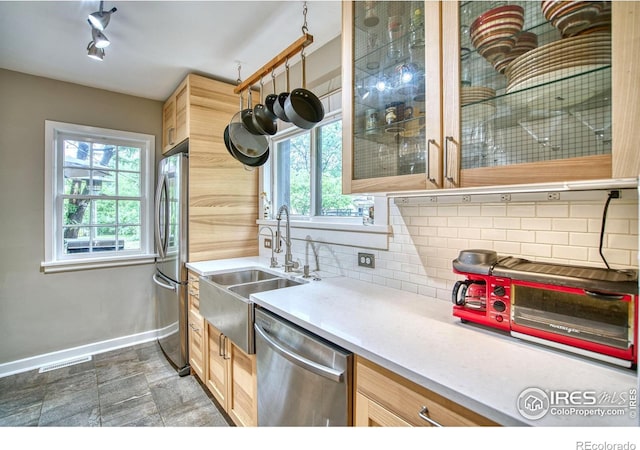 1233 Carolina Ave, Longmont, CO 80501 - kitchen with appliances with stainless steel finishes, a sink, baseboards, backsplash, and plenty of natural light