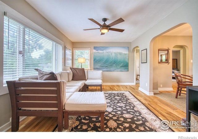 1233 Carolina Ave, Longmont, CO 80501 - living area with arched walkways, ceiling fan, and light wood-type flooring