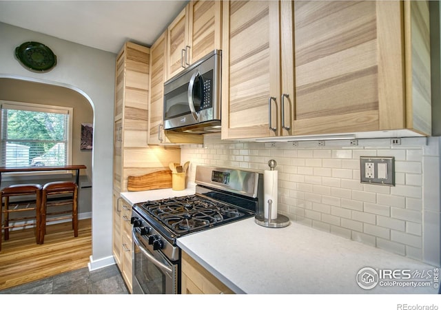1233 Carolina Ave, Longmont, CO 80501 - kitchen featuring stainless steel appliances, light countertops, light brown cabinets, and tasteful backsplash