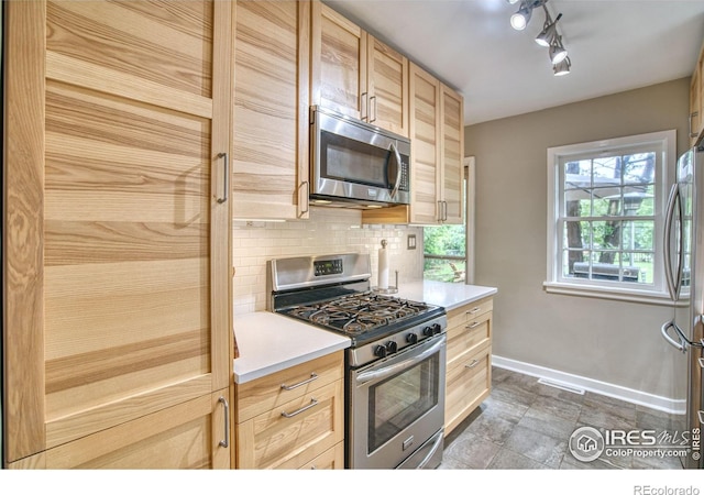 1233 Carolina Ave, Longmont, CO 80501 - kitchen featuring stainless steel appliances, light brown cabinetry, decorative backsplash, light countertops, and rail lighting