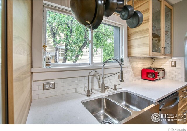 1233 Carolina Ave, Longmont, CO 80501 - kitchen with tasteful backsplash, light countertops, dishwasher, and glass insert cabinets
