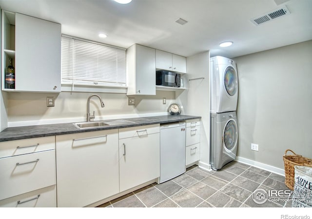 1233 Carolina Ave, Longmont, CO 80501 - kitchen featuring stacked washer and clothes dryer, dark countertops, black microwave, white cabinetry, and recessed lighting