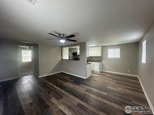 715 Cleveland St, Sterling, CO 80751 - unfurnished living room with a ceiling fan, dark wood-type flooring, and baseboards