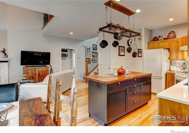 1421 Canal Dr, Windsor, CO 80550 - kitchen with freestanding refrigerator, butcher block countertops, gas range, open floor plan, and light wood finished floors