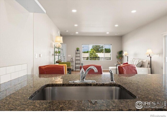 3635 Ronald Reagan Ave, Wellington, CO 80549 - kitchen featuring a sink, open floor plan, dark stone countertops, and recessed lighting