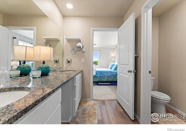 3635 Ronald Reagan Ave, Wellington, CO 80549 - full bathroom with wood finished floors, toilet, double vanity, ensuite bathroom, and baseboards