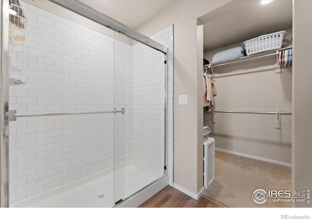 3635 Ronald Reagan Ave, Wellington, CO 80549 - bathroom with a spacious closet, a shower stall, and wood finished floors